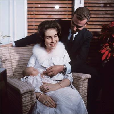 Queen Sofia holding Infanta Elena in 1963.