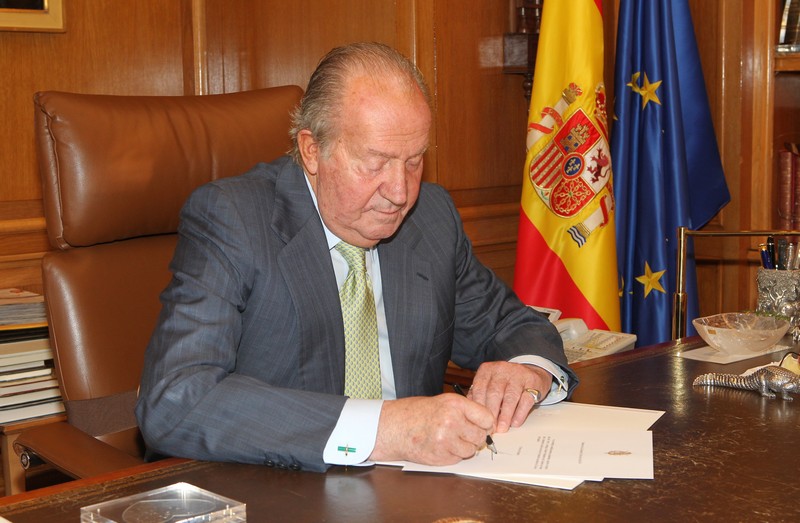 King Juan Carlos signing his abdication announcement.